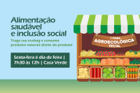 À direita da foto, uma barraquinha cheia de frutas e verduras: banana, morango, abacaxi, tomate, batatinha, cenoura. A barraca tem um tento listrado nas cores verde e branco e, abaixo do teto, uma plaquinha marrom com o nome 2ª feira agroecológica do TRT/AL. À esquerda da barraquinha, as frases alimentação saudável e inclusão social escrita em letra verde-escuros sobre um fundo azul claro e mais outras informações sobre a feira