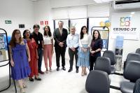 Na foto, todos em pé, cinco mulheres e três homens. Ao lado direito, a logomarca do Cejusc