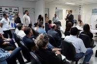 Foto mostra pessoas sentadas na sala de espera do Cejusc, tendo à frente o juiz Flávio Costa