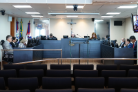 Foto do pleno no Tribunal com o presidente do órgão sentado ao centro da bancada; ao lado esquerdo três desembargadores sentados e, ao lado direito, dois desembargadores sentados
