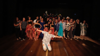 Grupo de pessoas, entre homens e mulheres, em cima de um palco 