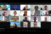 Tela de computador com rostos de homens e mulheres participando de reunião online