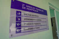 Placa nas cores azul,pretae e branca. Ela indica os recintos da 2ª Vara do Trabalho de Arapiraca.