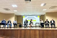Vários homens e uma mulher na parte alta de um auditório.
