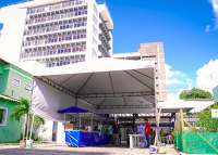 Tenda branca com barracas de feira na cor azul.