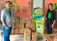 Há um homem e a mulher. Eles estão posando para foto entre várias caixas.