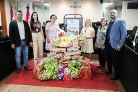 Há quatro mulheres e dois homens posando para foto. Sendo três pessoas se cada lado. Ao centro dessa foto,  há divresas embalagens de presentes.