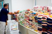 Há um homem de camisa escuro e calça clara. Ele está de frente a uma mesa com váriosvários quilos de alimentos.