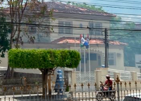 Imagem de um casa colonial de cor creme envolvida por uma fumaça cinza clara