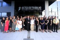 Na imagem, mais de 40 pessoas, entre homens e mulheres, todos de roupas sociais em frente ao prédio-sede do TRT de Alagoas