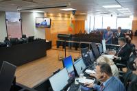 Há um plenário com várias pessoas lendo e dgitando em computadores.