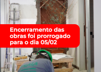 Há um local em obras de reforma. No centro da imagem tem uma tarja vermelha com letras brancas.