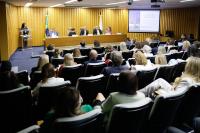 auditório com várias pessoas sentadas e três homens e duas mulheres na mesa de honra