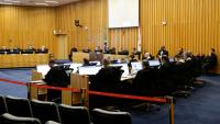 Foto de pleno do tst, com ministros sentados usando togas pretas; ao centro da bancada, um telão branco de projeção de slides.