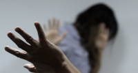 Mulher com uma mão no rosto e tem uma mão de outra pessoa levantada