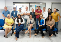 Várias pessoas, entre homens e mulheres, sentada posando para fotos