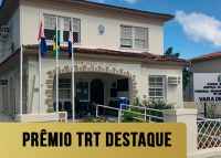 Fachada de um sobrado antigo bege com uma faixa amarela escrito em letras pretas Prêmio TRT Destaque