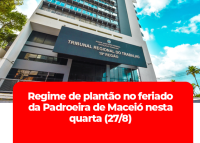 Fachada frontal do prédio-sede do TRT/AL, nas cores branca e azul. Há janelas de vidro. Tem uma tarja vermelha.
