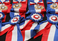 várias medalhas envoltas de faixas coloridas em vermelhor, azul e branco
