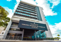 prédio cinza com placa preta e letras douradas com o nome Tribunal Regional do Trabalho da 19ªRegião