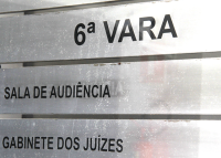 Placa cor cinza claro com o nome preto em destaque: 6ª Vara