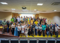 Grupo grande pessoas reunidos para uma foto em um palco.