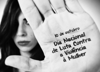 H[a um rosto de mulher. Com uma mãoi espalmada a sua frente. Na palama da ma~ão tem escrito 10 de outubro. Dia Nacional de Combate à Violência contra a Mulher 