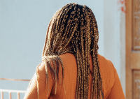 MULHER NEGRA COM CABELO EM TRANÇA AFRO