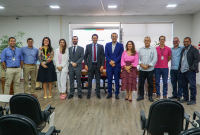 Grupo de pessoas reunidos em uma sala para uma foto.