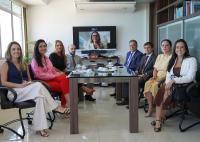 Quatro mulheres e três homens sentados em uma mesa