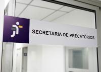 vidro com placa cinza com letras pretas escrito secretaria de precatórios