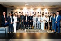 Grupo de autoridades e servidores posa para foto institucional em ambiente interno, em frente à “Galeria dos Presidentes do Poder Judiciário de Alagoas”, com um dos integrantes segurando um documento oficial.