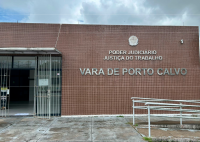 Fachada de cor marrom da Vara do Trabalho de Porto Calvo. Há uma rampa e também corrimão .