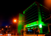 Fachada do prédio-sede do TRT/AL, iluminada na cor verde.