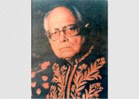Retrato de um homem idoso, de expressão séria, usando óculos e vestindo uma toga escura ricamente bordada com detalhes dourados. O fundo é neutro e escuro, destacando sua figura e conferindo um tom formal e solene à imagem.