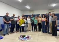 Foto de catorze pessoas em pé  posadas para a foto. Todas estão usando roupas informais.