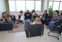 Grupo de mulheres sentadas em círculo com um homem de terno