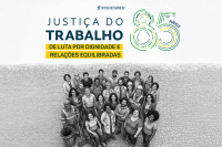 foto preta e branca de trabalhadores com o logo azul e verde justiça do trabalho 85 anos