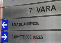 Placa de alumínio na core cinza. Há a indicação da 7ª Vara do trabalho, com seus setores.