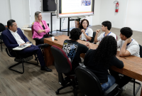 Várias pessoas reunidas em volta de uma mesa.