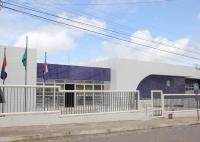 Fachada de Vara do Trabalho de União dos Palmares nas cores azul e branco. Há grades brancas e três bandeireas, sendo duas identificáveis, uma do Brasil e outra do Estado de Alagoas