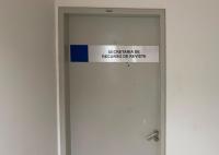 Porta de uma sala identificada com a placa "Secretaria de Recurso de Revista", localizada na sala 402. A porta é cinza, possui maçaneta metálica e está em um corredor de paredes brancas.