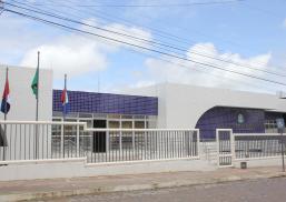 Fachada de Vara do Trabalho de União dos Palmares nas cores azul e branco. Há grades brancas e três bandeireas, sendo duas identificáveis, uma do Brasil e outra do Estado de Alagoas